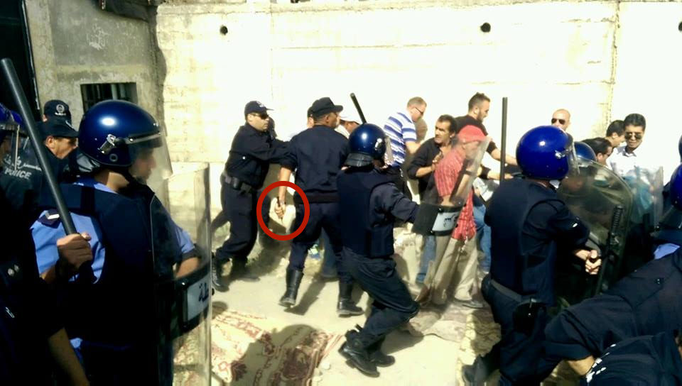 policier sortant un couteau lors d'un rassemblement à Iferhounène