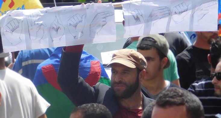 Menad Ait Gherbi tenant une banderole "AFRANIMAN" écrite en langue des signes le 20/04/2016 (PH/SIWEL)