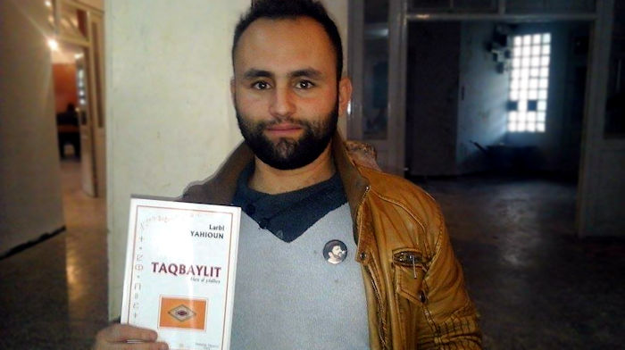Akli Muhubi tenant le livre "Taqvaylit" de Larbi Yahioun