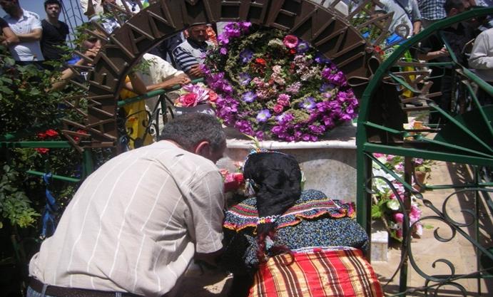 Nna Wiza, veuve de martyr de la guerre d’Algérie, et mère de Ferhat Mehenni, déposant une gerbe de fleurs sur la tombe de son petit-fils Ameziane assassiné à Paris par les services algériens à la place de son père.(PH/DR)