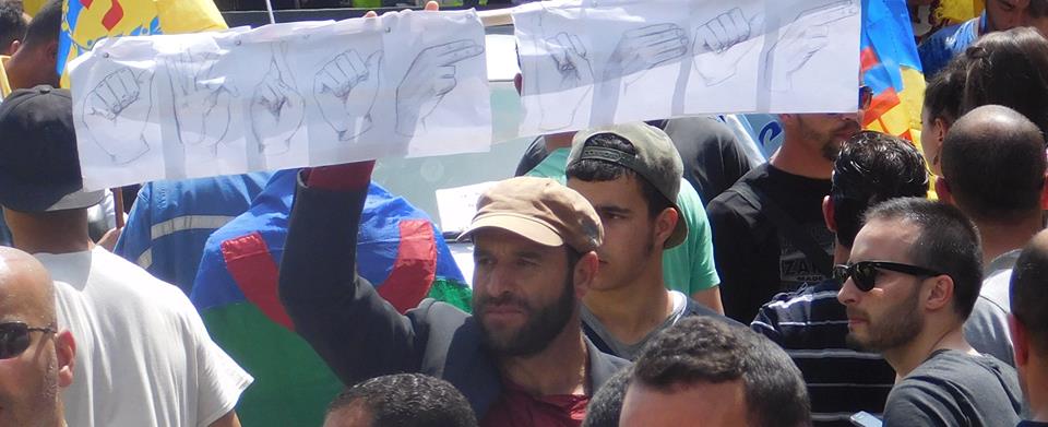Le souverainiste kabyle Menad Ait Gherbi arborant le message en langue des signes (PH/SIWEL)